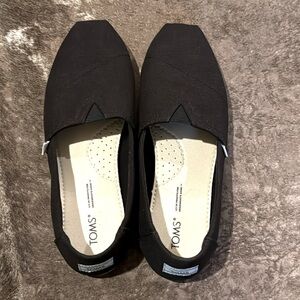 Tom’s canvas black slip ons